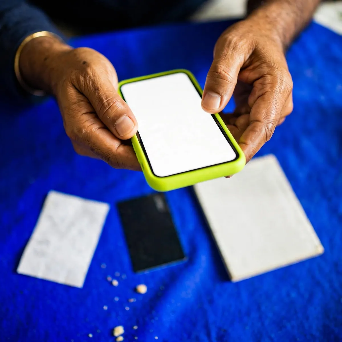 Parent paying a tuition class fee online from a mobile phone, with a bank slip on the table